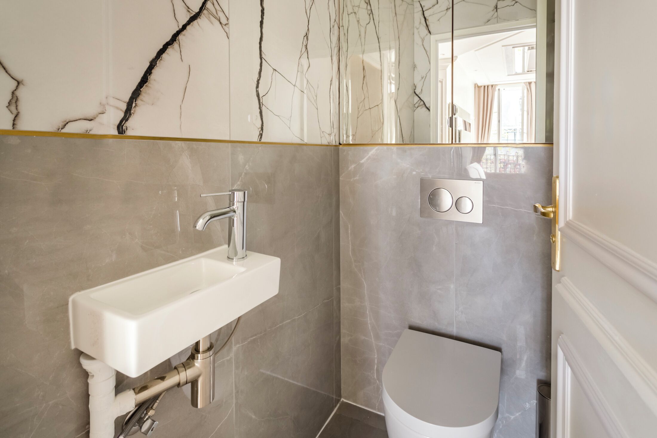 A bathroom with a white sink, a toilet, and a mirror.