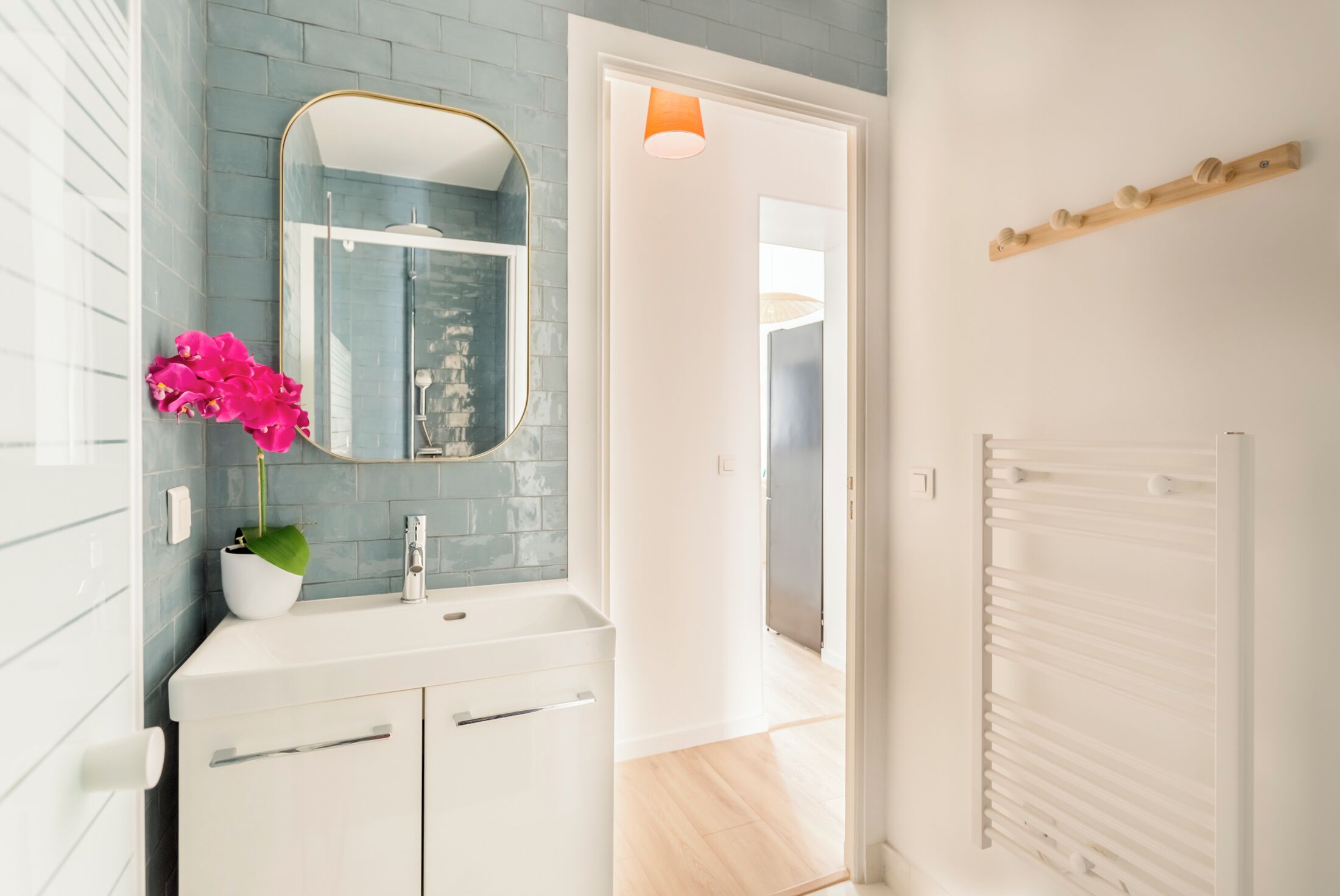 A bathroom with a white sink, a mirror, and a shower.