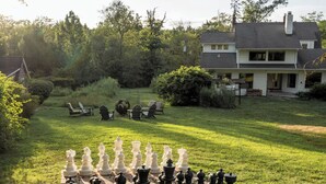 A chessboard set up on a lawn with a house in the background. - Terrific 5-bedroom house with AC in charming Princeton (Princeton)