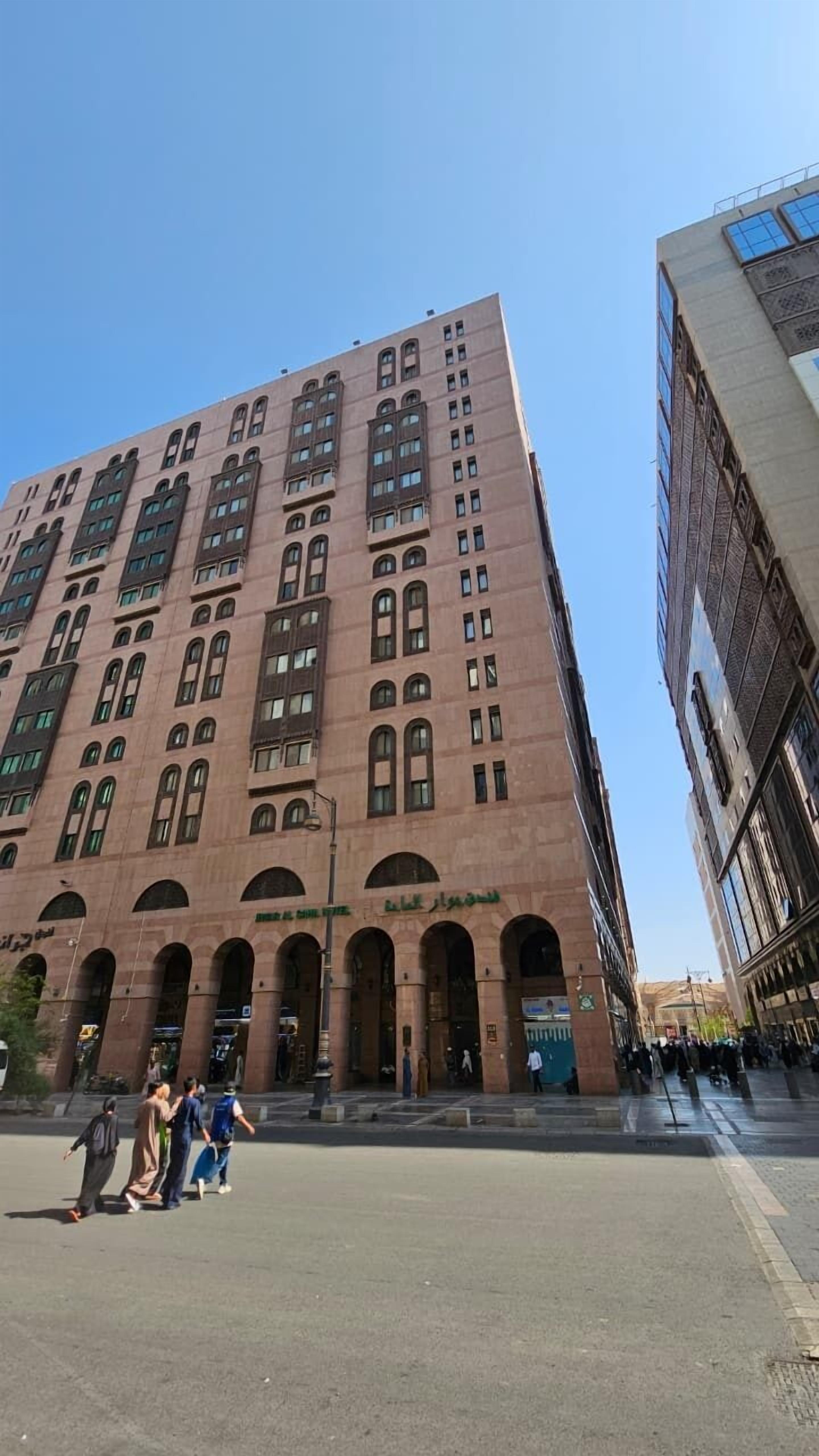 A large, multi-story building with a prominent arched entrance and a series of windows.