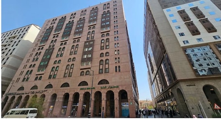 A multi-story building with arched windows and a beige facade.