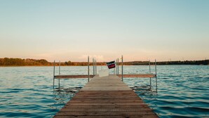 Une jetée en bois s’étendant sur un lac paisible, avec une pancarte indiquant : « Désolé, nous sommes fermés ».