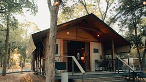 Un chalet rustique avec une façade en bois, une véranda et un escalier menant à l’entrée.