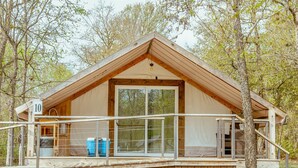 Une cabane en bois dotée d’une grande fenêtre, d’un balcon et d’un panneau indiquant son numéro.