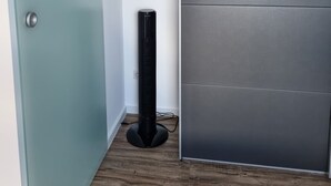 Ein Zimmer mit einer türkisblauen Tür, einem schwarzen Standheizgerät und einer grauen Schiebetür.