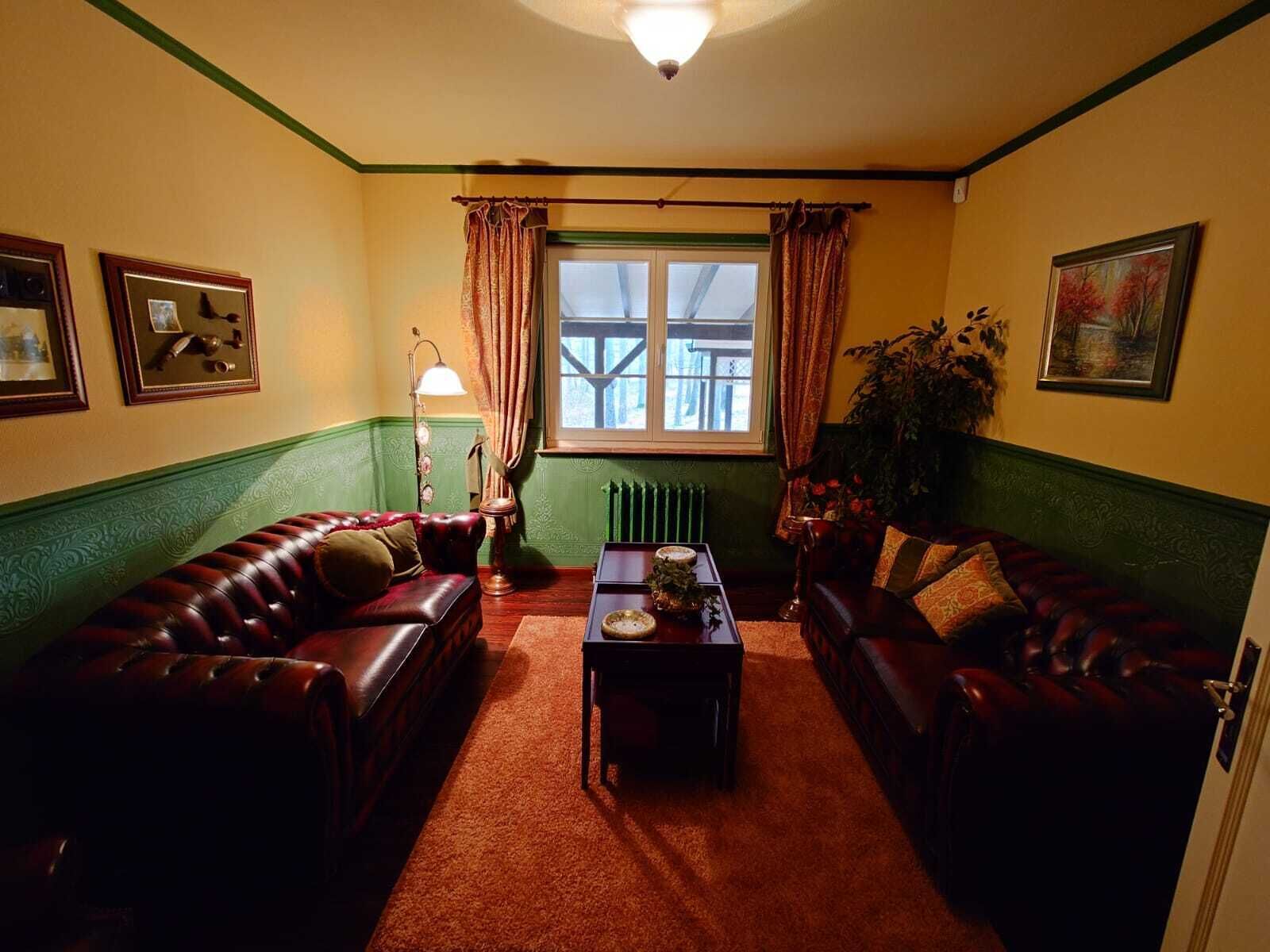 A cozy living room with two leather sofas, a coffee table, and a floor lamp.