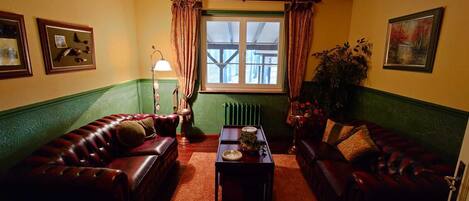 A cozy living room with two leather sofas, a coffee table, and a floor lamp.