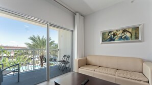 A modern living room with a sofa, a coffee table, and a painting on the wall.