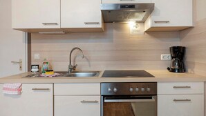 Una cucina moderna con cappa in acciaio inossidabile, forno a incasso e macchina per il caffè.
