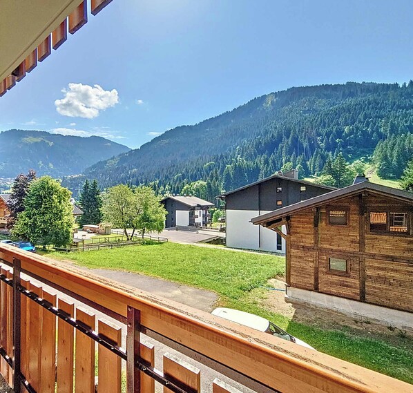 Eine Berglandschaft mit einem Holzhaus und einem modernen Gebäude.