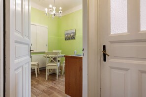 Una habitación con comedor, una puerta blanca y una araña.