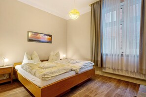 Une chambre à coucher avec un lit, une table de chevet, une lampe et un tableau au mur.