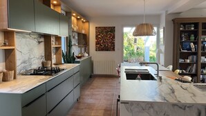A modern kitchen with marble countertops, built-in cabinets, and a central island. - Villa VISTA - 4 bedrooms, swimming pool, sea view (PORTICCIO)