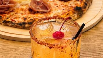 A pizza with prosciutto and a creamy topping on a wooden board.