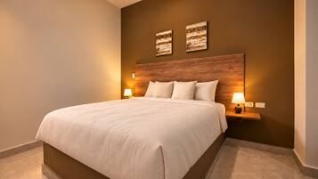 Una habitación de hotel con una cama grande, dos lámparas de noche y un cabecero de madera.