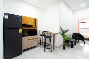 Cafetera/tetera, microondas, utensilios de cocina, mesa de comedor