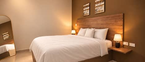 A modern hotel room with a large bed, bedside tables with lamps, and artwork on the walls.
