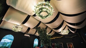 A venue with a high ceiling featuring draped fabric and circular light fixtures. - La Palma Experience (Panama City)