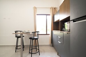 Cafetera/tetera, microondas, utensilios de cocina, mesa de comedor
