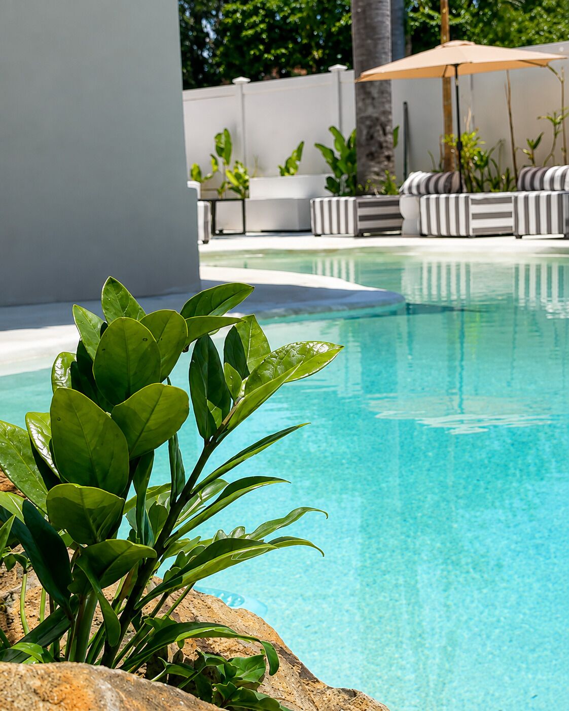 A clear pool with a lounge area in the background.