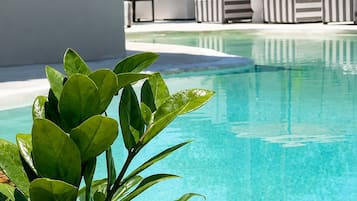 A clear pool with a lounge area in the background.