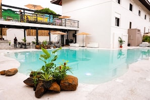 An indoor swimming pool with a clear water surface, surrounded by rocks and potted plants. - La Palma Experience (Panama City)