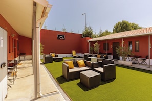 An outdoor patio with artificial grass, wicker furniture, and a basketball hoop. - Magnolia Inn (Aveiro)