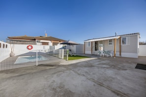 A residential property with a swimming pool, a fenced area, and a patio with outdoor furniture.