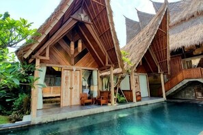 A resort with thatched-roof structures, a pool, and outdoor seating. - Premadhan Sanctuary (Bali)