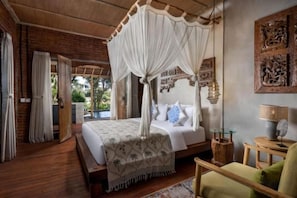 A bedroom with a four-poster bed, a wooden floor, and a view of the outdoors. - Premadhan Sanctuary (Bali)