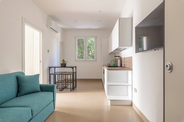 A modern kitchen with white cabinets, a built-in microwave, and a large window. - Crispi Suite in Palermo by Wonderful Italy (Palermo)