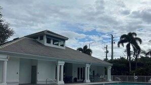 A poolside area with lounge chairs, a covered patio, and a swimming pool. - Beautiful  2-bedroom/2-bath condo with AC close to beach & shopping in  Naples (Naples)