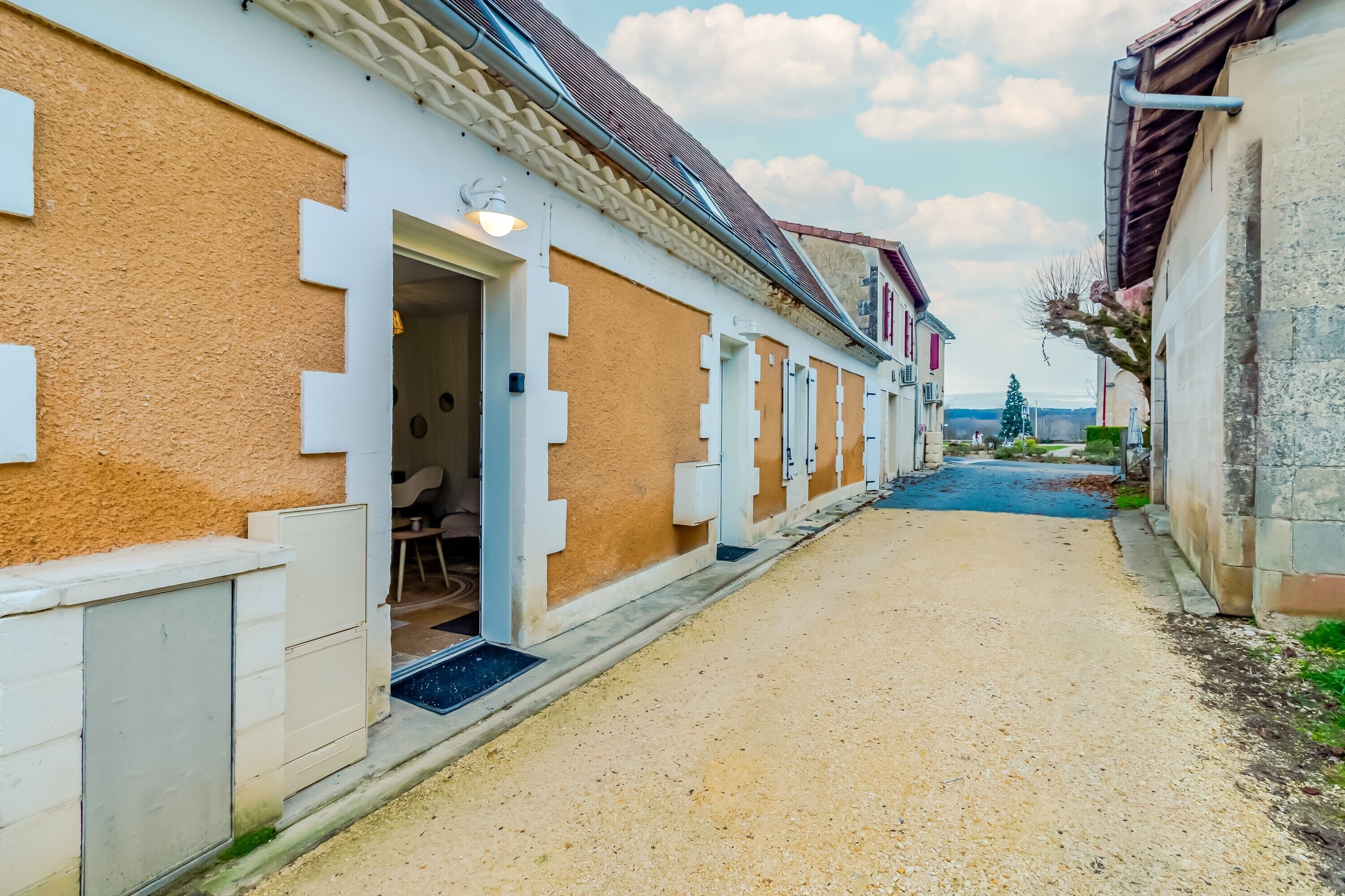 Un vicolo stretto con edifici su entrambi i lati, con una porta, un lampadario e un piccolo scalino d'accesso a un edificio.