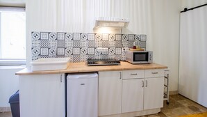 Eine kleine Küche mit Mikrowelle, Toaster und Spüle.