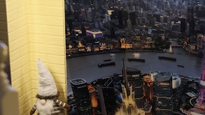 Une maquette représentant un paysage urbain, avec une figurine de gnome posée sur une étagère.