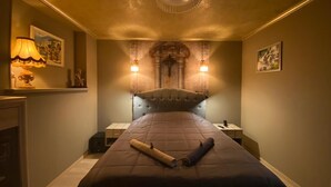 Une chambre d’hôtel avec un grand lit, un lustre et des lampes fixées au mur.