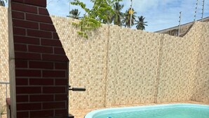 A swimming pool with a brick structure and stone tiles.