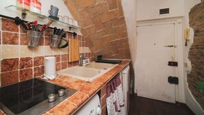 Une cuisine avec une arche en pierre, un évier et une cuisinière.
