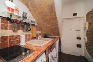 A kitchen with a stone arch, a sink, and a stove.