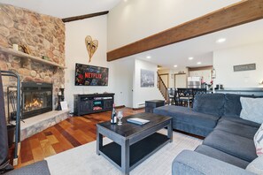 Télévision, cheminée, table de tennis de table, livres