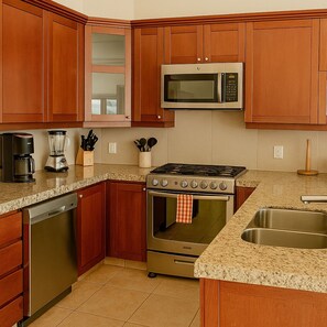 A kitchen with wooden cabinets, a stainless steel microwave, a gas stove, and a dishwasher.
