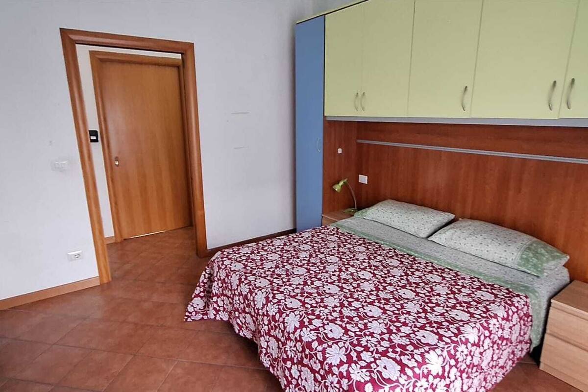 Un dormitorio con una cama, un armario y una puerta.