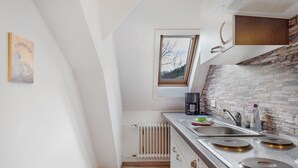 A modern kitchen with a stone backsplash, a window with a view, and a radiator. - 'Elzblick' Apartment with Shared Pool, Garden, and Wi-Fi (Elzach)