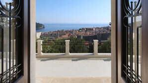 Ein offenes Portal mit Blick auf eine Küstenstadt, einschließlich Gebäude und eines Gewässers.