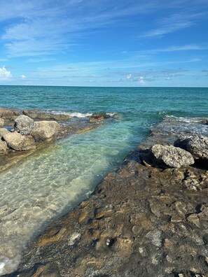Una costa rocosa con aguas cristalinas y vista al océano.