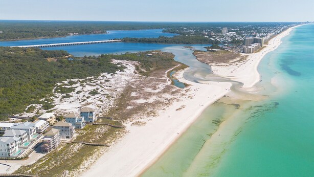 An aerial view of a coastal area with a beach, a bridge, and buildings along the shore. - 30A Gem • Steps to Sand • Balcony Sunsets • Pool (Inlet Beach)