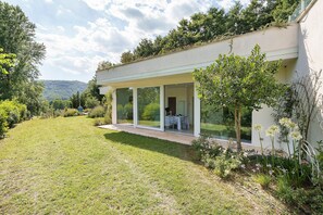 A modern house with a covered patio, a lawn, and a garden with flowers. - Apartment 1 with Lake View (Alvignano)