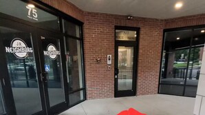 Entrada de un edificio con puertas de vidrio que indican 
