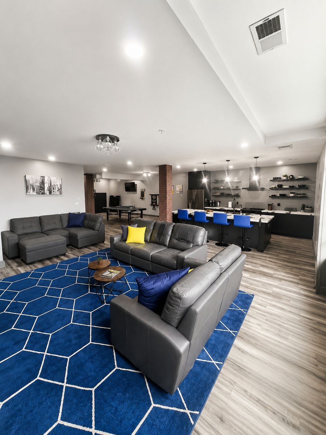 Una sala de estar moderna con un sofá modular, una mesa de centro y una alfombra azul estampada.