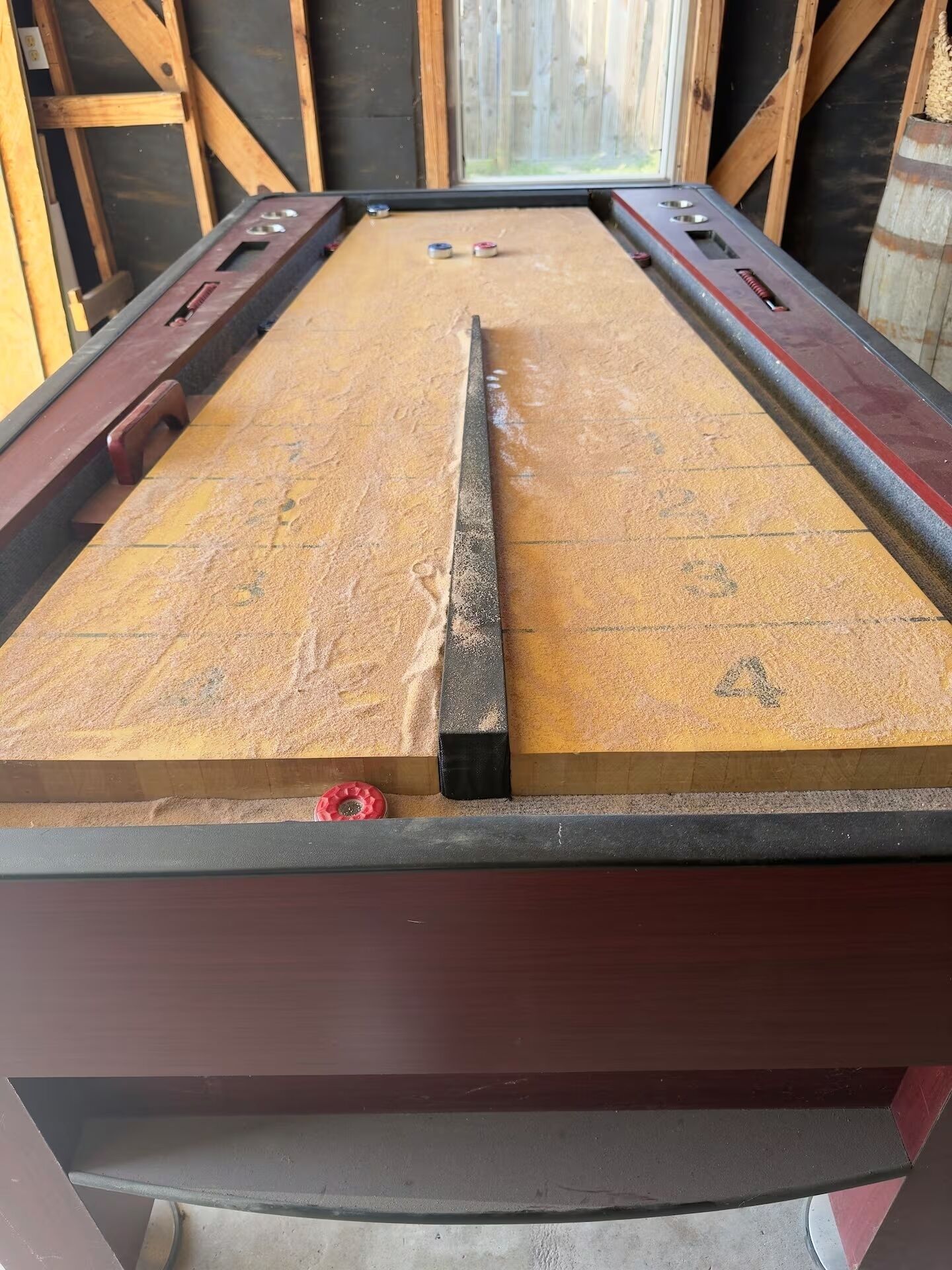 Ein Billardtisch mit abgenutzter Spielbahn, Holzrahmen und einem roten Griff.